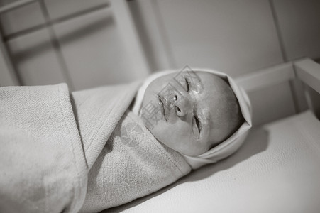 新生儿出生后包扎的婴儿躺在桌子上 黑白相片妈妈高清图片素材