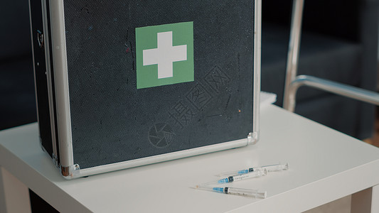 桌子上医疗箱将医疗手提箱和注射器放在桌上的保健设备贴上药品注射机动性工具案件病人公文包桌子卫生治疗背景