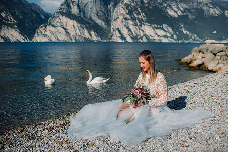 蓝发蓝礼服女孩一名女性在意大利一座山和湖的背景下被拍到照片 Torbole Torbole 的作者 Look Garda衣服微笑蓝色头发女士裙背景