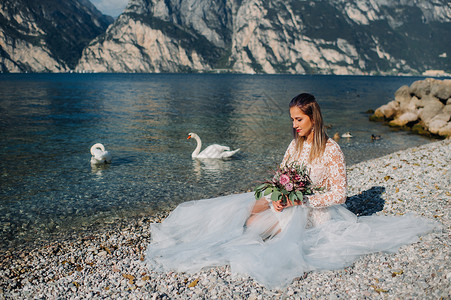 蓝发蓝礼服女孩一名女性在意大利一座山和湖的背景下被拍到照片 Torbole Torbole 的作者 Look Garda礼服公主快乐天鹅山脉公背景