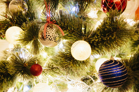 贴上圣诞树装饰品的特写照片假期金子装饰庆典派对风格黄色绿色季节松树背景图片