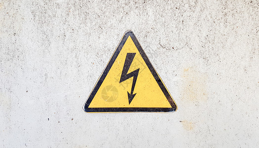 黄色闪电高压电的危险标志 中间有闪电的黄色三角形标志 此警告写在涂有灰色油漆的旧金属表面上背景