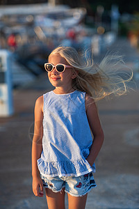 蓝色小短裤身穿短裤 穿着蓝T恤的土耳其女孩 在海边日落时穿蓝色T恤幸福火鸡头发孩子们孩子微笑衣服海滨金发女郎女儿背景