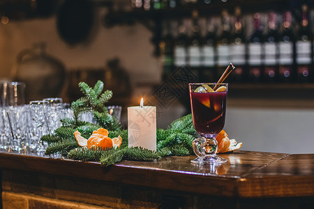 格林诺夫饮料红热饮料格林特温 香料 肉桂 火花 水果 棕色糖放在旧木制桌上 新年和圣诞假期概念玻璃酒精八角橙子蜡烛花环庆典杯子背景