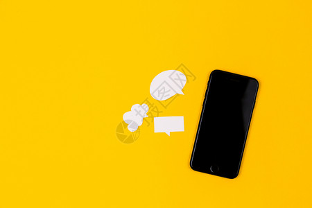 黄色卡通电话黄色背景上带有纸泡泡的智能手机 沟通理念 顶视图 复制空间 论文作文信使消息短信展示桌子标签讲话技术讨论互联网背景