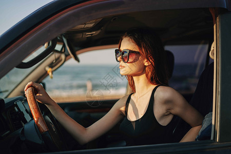 戴着太阳眼镜的开心女人 驾车出行旅行女孩车辆交通头发眼镜微笑司机窗户乘客魅力天高清图片素材