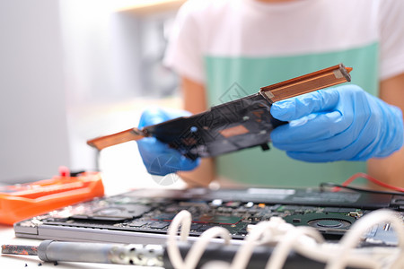 手套手握着计算机的备用零件处理器芯片维修硬件母板螺丝刀焊接连接器晶体管修理工维护高清图片素材