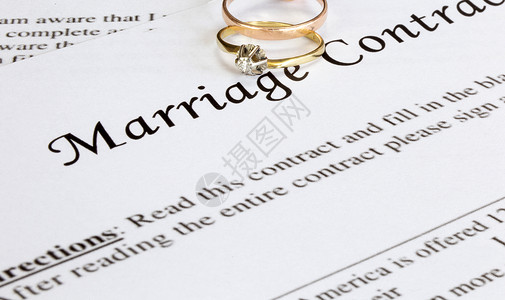 与两个金婚戒指和金笔的婚姻合同 婚前协议 宏观特写 签名 文件 协议概念商业文档法令证书婚礼订婚离婚律师假期家庭快乐的高清图片素材