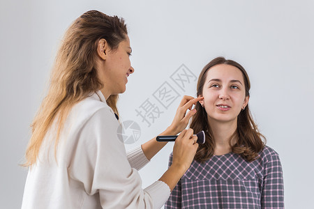美容和化妆品概念     从事专业工作的化妆艺术家由年轻妇女组成刷子眉毛魅力眼睛成人客户女士美容师眼影肤色脸高清图片素材