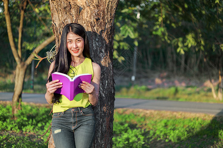 合成的书和树图女人在树上画画 在公园里看书女性学生牛仔裤成人阅读休息教育微笑快乐学习背景