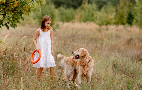 查理王小猎犬有金色猎犬的女孩朋友犬类女性童年场地自由草地日落闲暇晴天背景