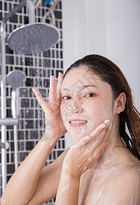 泡沫中的女孩在淋浴泡沫中洗脸的妇女微笑治疗洗涤温泉洗澡清洁肥皂女性女士护理背景