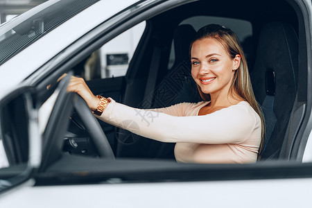 年轻有魅力的天主教女青年坐在新买的汽车里微笑女性顾客女士旅行车辆车窗乐趣快乐幸福所有者高清图片素材
