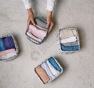垂直而下在现代存储系统的帮助下 一位整洁的家庭主妇在进行一般清洁时将物品放入洗衣容器中 顶视图 一个美丽舒适的组织的概念毛巾衣服房子案例背景