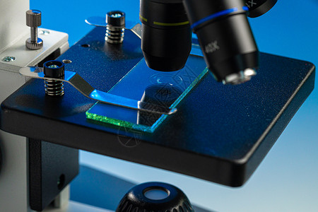 显微镜头检查玻璃样品的显微镜镜头近照照片研究微生物学生物样本镜片实验室盘子乐器药品光学背景
