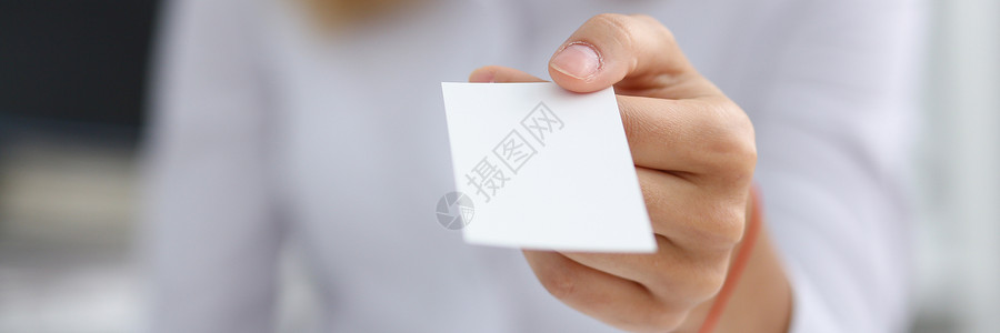 穿白衬衫的女性手给空白电话卡广告高清图片素材