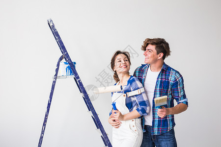 人 重新装配和修理概念可爱的年轻夫妇在新公寓里进行翻新维修微笑夫妻男性男人墙纸改造牛仔裤胶水女士背景图片