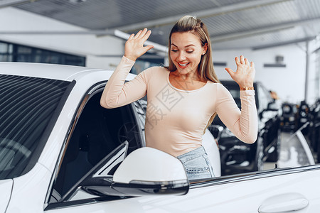 年轻有魅力的天主教女青年坐在新买的汽车里车窗微笑运输车辆快乐女士女性驾驶顾客幸福快乐的高清图片素材
