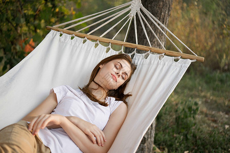 妇女睡在吊床室户外睡觉的休闲生活方式青少年假期旅行蓝色休息室地平线花园露台女士女孩懒惰的高清图片素材