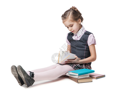 看书的漂亮女孩穿着校服 书坐在地板上的漂亮女孩 身着校服百科童年学习智慧女性女孩训练科学乐趣全书背景