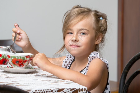 小女孩在喝茶乐趣咖啡快乐微笑早餐女性童年母亲食物桌子女儿高清图片素材