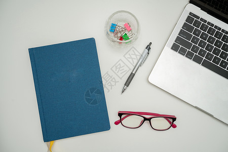 办公桌上的办公用品 包括键盘 眼镜和用于远程工作的咖啡杯 用于学习的各种学校公用设施 包括热饮和眼镜互联网职业材料铅笔木头计算机背景