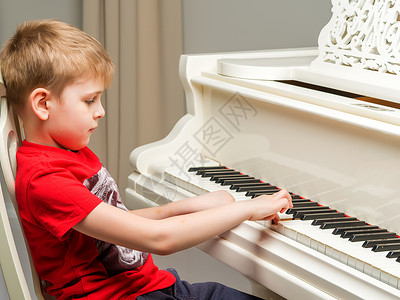 有个小男孩在弹钢琴导师演员床单键盘教育辅导乐队闲暇老师器官合成器高清图片素材
