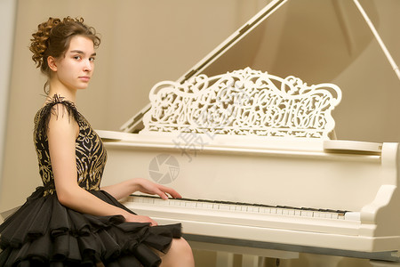 一个十几岁的女孩在弹白色大钢琴旋律学生训练学校钢琴家音乐会艺术闲暇青少年学院漂亮的高清图片素材