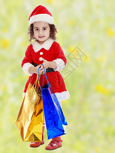 穿着圣诞老人装扮的小女孩 带着色彩多彩的包裹乐趣帽子展示礼物盒子季节幸福假期孩子们快乐小的高清图片素材