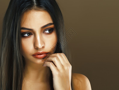 黑色化妆品在演播室的可爱快乐的印度年轻女士 以棕色背景微笑 时装美容生活方式概念头发黑发魅力优雅工作室棕褐色化妆品发型女性姿势背景