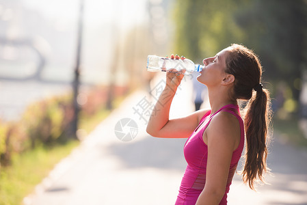 可以喝的水妇女慢跑后从瓶子里喝水娱乐赛跑者活动城市身体活力跑步运动训练女士背景