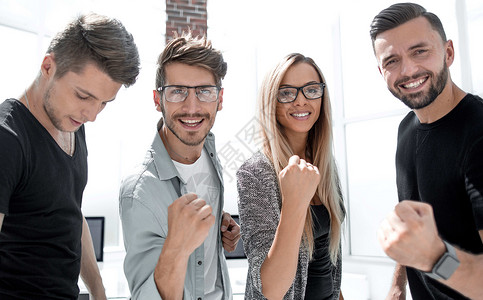 商业团队在办公室庆祝工作成绩优异手势微笑女士男人乐趣男性女性幸福商务喜悦背景图片