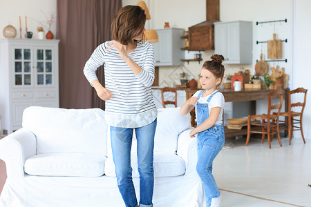 快乐的母亲和小女儿 在家中客厅最喜爱的歌唱中跳舞孩子们女士公寓保姆沙发乐趣妈妈母性舞蹈朋友背景图片