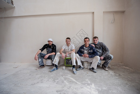 公寓内穿着肮脏制服的工人和建筑工人肖像会议装修房间工具维修团队安全水泥男人工作背景图片