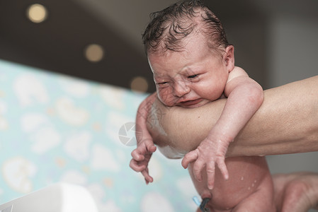 刚出生的女婴第一次洗澡女儿保健妈妈父母幸福浴缸母亲卫生童年女孩背景图片