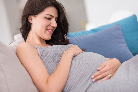 保持冷静等待在家沙发上坐着的孕妇房子婴儿思维女性怀孕腹部公寓女士家庭生活背景