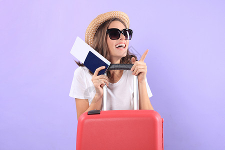 穿暑期临时服装的年轻旅游女孩 带太阳眼镜 红色手提箱 紫底护照和孤立的紫底护照女士航空公司旅游飞机场闲暇冒险紫色女性航程案件紫色的高清图片素材