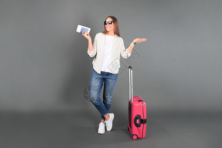穿暑期散装的年轻旅游女孩 有太阳镜 红色手提箱 护照 机票和孤立的灰色背景行李树干案件旅行闲暇女士旅游手提包休息商业灰色的高清图片素材