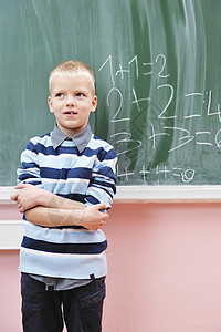 小学一年级数学班快乐的年轻男孩桌子班级男生知识解决方案微笑家庭作业黑板思考专注背景图片