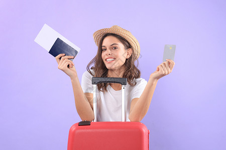穿暑期临时服装的年轻旅游女孩 带太阳眼镜 红色手提箱 紫底护照和孤立的紫底护照手提包闲暇假期旅行航空公司飞机场商业树干女士冒险案件高清图片素材