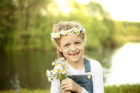 黄色小菊花花环一个小女孩的肖像画 在花圈 菊花和花束冒充草地洋甘菊假期幸福照片闲暇孩子花环游戏背景