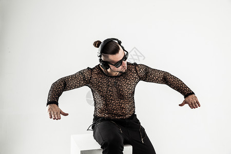 DJ  在时尚的T恤里唱唱歌手 带耳机和手霹雳舞脚尖快乐霹雳舞者精力帽子夜生活冒充配件玩家背景图片