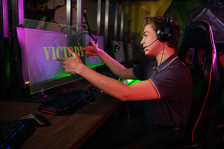 耳机带字素材专业的年轻caucasian 球员在电脑上玩游戏 他因为输了比赛而心烦意乱键盘玩家享受电子竞技青少年娱乐运动男人监视器展示背景