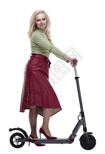 红色滑板车微笑着的女士在一辆电动摩托车上行驶工具木板引擎广告裙子衣服享受技术喜悦车轮背景