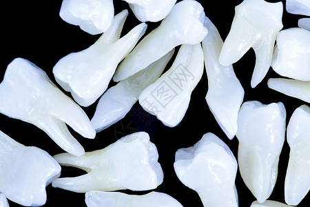 黑色背景的白牙药品萃取空腔治疗牙疼鞑靼口腔科解剖学凹痕牙医图片