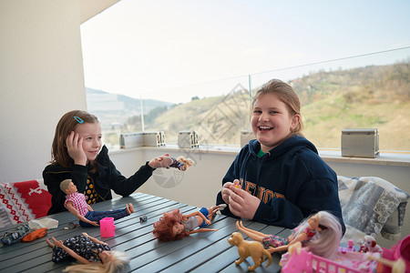 小女孩玩玩洋娃娃桌子游戏乐趣学校阳台闲暇女士女孩们玩具隔离图片