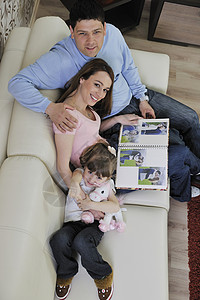 家庭幸福的家庭在家里看相片妈妈男人房子生活成人沙发女性父母孩子们夫妻图片