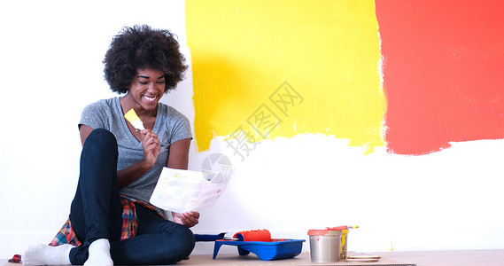坐在地板上的黑人女性画家刷子房间工作成人装潢装修滚筒设计师女孩公寓人们高清图片素材