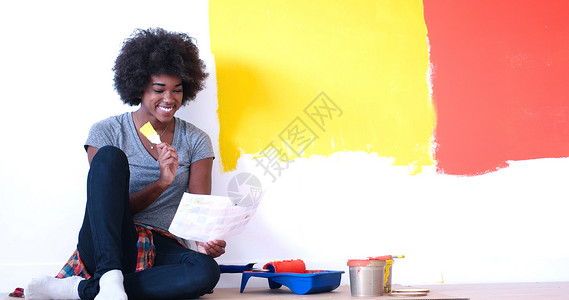 坐在地板上的黑人女性画家设计师公寓快乐房间房子维修女士画笔工作成人在室内高清图片素材