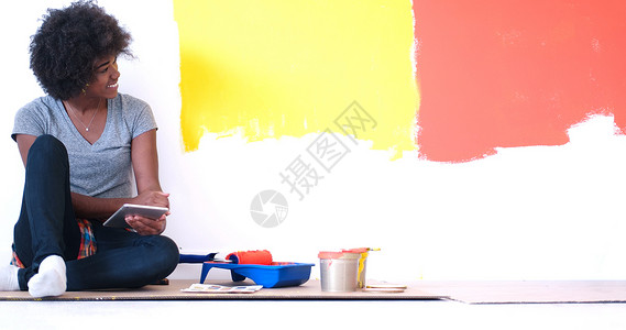 坐在地板上的黑人女性画家工作装潢快乐女孩女士公寓绘画房子设计师维修非裔美国人高清图片素材